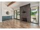 Open living area with wood-look flooring, fireplace, wet bar, and bright sliding glass doors at 225 W Winged Foot Rd, Phoenix, AZ 85023