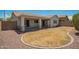 Charming backyard featuring a small patch of grass, rocks, and covered patio at 25732 W Elizabeth Ave, Buckeye, AZ 85326