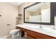 Well-lit bathroom featuring a white vanity, a big mirror, a sink, a toilet, and floating wood shelves at 25732 W Elizabeth Ave, Buckeye, AZ 85326