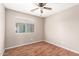This bedroom has a ceiling fan, neutral colored walls, hardwood floors and a window for great natural light at 25732 W Elizabeth Ave, Buckeye, AZ 85326