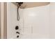 The updated shower features white tile surround and a black shower head with a sleek design at 25732 W Elizabeth Ave, Buckeye, AZ 85326