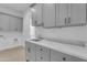 Well-equipped laundry room with gray cabinets, sleek countertops, and plenty of storage space at 28834 N 175Th Ave, Surprise, AZ 85387