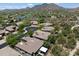 Community aerial view showcasing homes, lush green landscaping, a lake, and scenic mountain views at 33667 N 71St Way, Scottsdale, AZ 85266