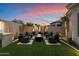 Cozy outdoor seating area with a fire pit, built-in grill, and lush landscaping at 33667 N 71St Way, Scottsdale, AZ 85266