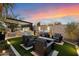 Outdoor living area featuring a fire pit, built-in grill, water feature, and comfortable seating at 33667 N 71St Way, Scottsdale, AZ 85266