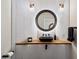 Chic powder room with a vessel sink, wood countertop, round mirror, and stylish lighting at 33667 N 71St Way, Scottsdale, AZ 85266