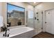 Bright bathroom featuring a soaking tub, glass enclosed shower and desert views at 33667 N 71St Way, Scottsdale, AZ 85266