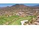 Expansive aerial view of the golf course showcasing manicured greens, community, clubhouse, and stunning desert landscape at 33667 N 71St Way, Scottsdale, AZ 85266