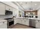 Contemporary kitchen featuring stainless steel appliances, white cabinetry, and modern lighting fixtures at 33667 N 71St Way, Scottsdale, AZ 85266