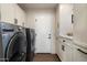 Bright laundry room with modern washer and dryer, ample cabinet space, and neutral tones at 33667 N 71St Way, Scottsdale, AZ 85266
