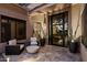 Cozy covered patio with modern furniture, potted plants, and sleek black-framed windows/doors at 33667 N 71St Way, Scottsdale, AZ 85266