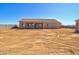 View of back exterior with covered patio, block wall, and desert-ready back yard at 3850 N Mateo Dr, Eloy, AZ 85131
