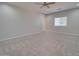 Spacious bedroom with neutral carpet, ceiling fan, and a bright window at 3850 N Mateo Dr, Eloy, AZ 85131