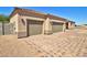 A desert home featuring a three-car garage, low maintenance landscape, and a paver driveway at 3850 N Mateo Dr, Eloy, AZ 85131