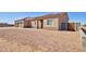 Side view of a desert home featuring a three-car garage, low maintenance landscape, and a paver driveway at 3850 N Mateo Dr, Eloy, AZ 85131