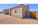 Side view of a desert home featuring a low maintenance landscape, block perimeter fence and wooden gate at 3850 N Mateo Dr, Eloy, AZ 85131