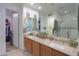 Double sink bathroom with granite countertops, a large mirror, and access to a walk-in closet at 3855 S Mcqueen Rd # 12, Chandler, AZ 85286