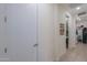 Neutral hallway with a closed white door and an open door to a powder room/laundry room at 3855 S Mcqueen Rd # 12, Chandler, AZ 85286