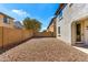 Low-maintenance backyard with gravel landscaping, block wall, and view of mature trees at 3875 E Claxton Ave, Gilbert, AZ 85297