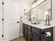 Bathroom with a vanity featuring dark cabinets, a mirror, and modern lighting at 3875 E Claxton Ave, Gilbert, AZ 85297