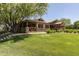Exterior view of community clubhouse on a green lawn with a large tree at 3875 E Claxton Ave, Gilbert, AZ 85297