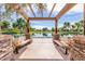 Scenic park view with benches under a pergola, colorful flowers, and tranquil lake setting, perfect for relaxation at 3875 E Claxton Ave, Gilbert, AZ 85297