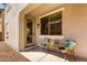 Charming covered patio with two wicker chairs and a small table, perfect for relaxation at 3875 E Claxton Ave, Gilbert, AZ 85297