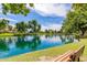 Picturesque lakeside view with vibrant landscaping, a relaxing bench, and tranquil pond at 3875 E Claxton Ave, Gilbert, AZ 85297