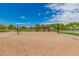 Community sand volleyball court on a clear day, featuring blue accents around the perimeter at 3875 E Claxton Ave, Gilbert, AZ 85297