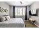 This bedroom features a large window, a bed, a television and nice decorations on the wall at 5345 E Van Buren St # 209, Phoenix, AZ 85008