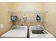 The laundry room boasts modern washer and dryer units with shelving for supplies at 5345 E Van Buren St # 209, Phoenix, AZ 85008