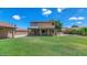 A large backyard with a well-manicured lawn, covered patio, and mature landscaping at 5787 W Barbara Ave, Glendale, AZ 85302