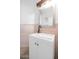 This powder room features wood style wainscoting, decorative mirror and a white vanity at 5787 W Barbara Ave, Glendale, AZ 85302