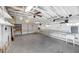 Spacious garage with exposed ceiling beams, a ceiling fan, and ample shelving, ideal for storage and projects at 5787 W Barbara Ave, Glendale, AZ 85302