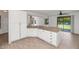 Well-designed kitchen features white cabinetry, granite countertops, and a pass-through to the living area at 5787 W Barbara Ave, Glendale, AZ 85302