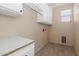 A well-lit laundry room with ample storage, tile flooring and convenient utility connections at 5787 W Barbara Ave, Glendale, AZ 85302