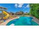A sparkling in-ground pool with diving board and slide next to the playground area at 5787 W Barbara Ave, Glendale, AZ 85302