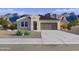 Charming single-story home featuring desert landscaping and a two-car garage, set against a stunning mountain backdrop at 5842 E Axle Ln, San Tan Valley, AZ 85140