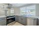 Modern kitchen featuring stainless steel appliances, gray cabinets, white countertops, and a view of the pool at 6214 W Sunnyside Dr, Glendale, AZ 85304