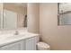 Bathroom features a white sink vanity, toilet, neutral paint, and window providing natural light at 6337 W Valencia Dr, Laveen, AZ 85339
