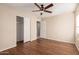 Bedroom with closet, wood floors, ceiling fan and nearby ensuite bathroom at 6337 W Valencia Dr, Laveen, AZ 85339