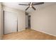 This bedroom features a ceiling fan, wood floors, closet and neutral paint at 6337 W Valencia Dr, Laveen, AZ 85339