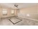 Bonus room with a decorative floor design, ceiling fan, white railing, and windows for natural light at 6337 W Valencia Dr, Laveen, AZ 85339