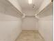 Walk-in closet with tile flooring, overhead lighting, and ample shelving space for storage at 6337 W Valencia Dr, Laveen, AZ 85339