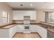 Well-lit kitchen showcasing ample counter space, white cabinetry, and modern appliances with a window view at 6337 W Valencia Dr, Laveen, AZ 85339