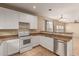 Kitchen with open layout, showcasing stainless steel appliances, tile flooring, and a view to dining area at 6337 W Valencia Dr, Laveen, AZ 85339