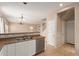 Kitchen with stainless steel dishwasher, double sink, and a pass-through to the dining area and staircase at 6337 W Valencia Dr, Laveen, AZ 85339