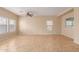 Spacious living room with tiled floors, neutral walls, ceiling fan, and abundant natural light from the windows at 6337 W Valencia Dr, Laveen, AZ 85339