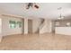 Spacious living room with tiled floors, neutral walls, ceiling fan, and abundant natural light from the windows at 6337 W Valencia Dr, Laveen, AZ 85339