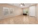 Spacious living room with tiled floors, neutral walls, ceiling fan, and abundant natural light from the windows at 6337 W Valencia Dr, Laveen, AZ 85339